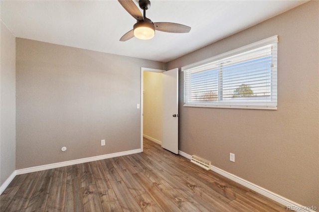 spare room with ceiling fan and light wood-type flooring