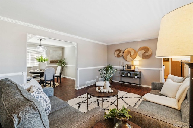 living room with dark hardwood / wood-style floors and crown molding