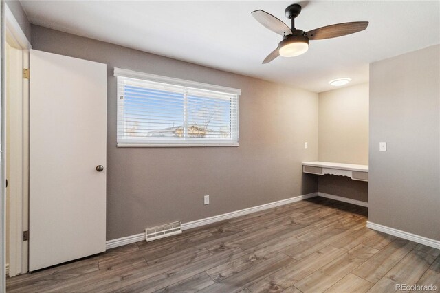 unfurnished room with hardwood / wood-style flooring and ceiling fan