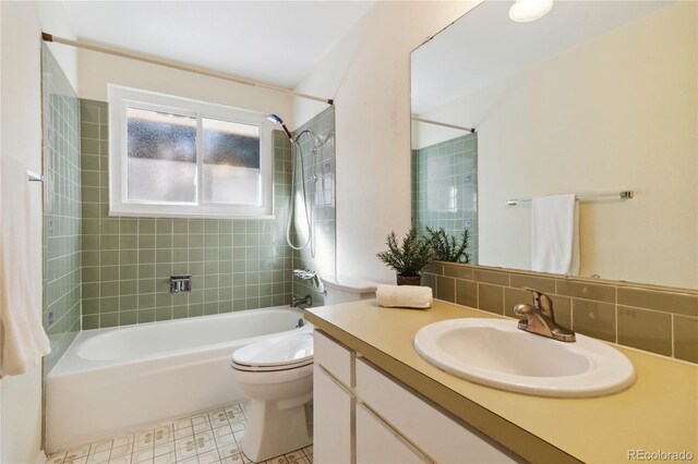 full bathroom featuring tiled shower / bath, tile patterned floors, vanity, decorative backsplash, and toilet