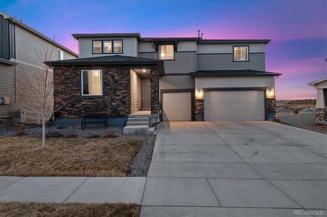 view of front of property with a garage, stone siding, and concrete driveway