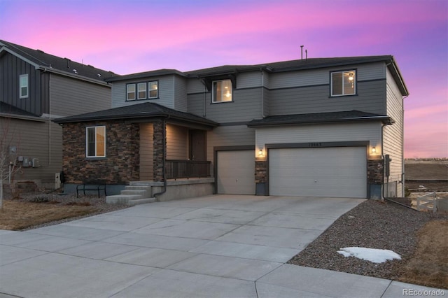 view of front of home featuring stone siding, driveway, and an attached garage