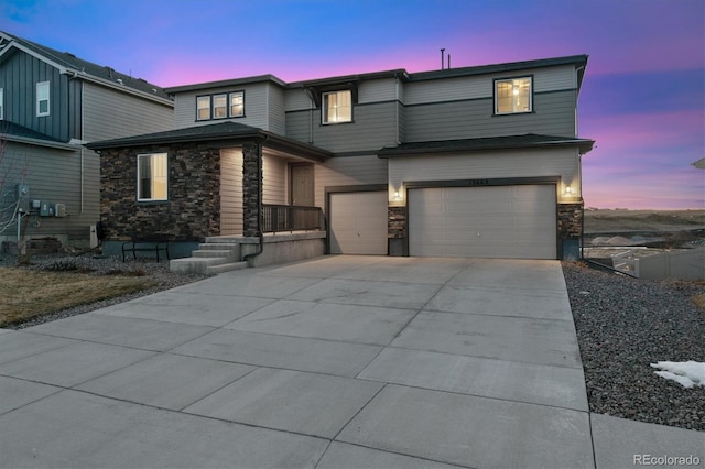 view of front of property with concrete driveway, stone siding, and an attached garage