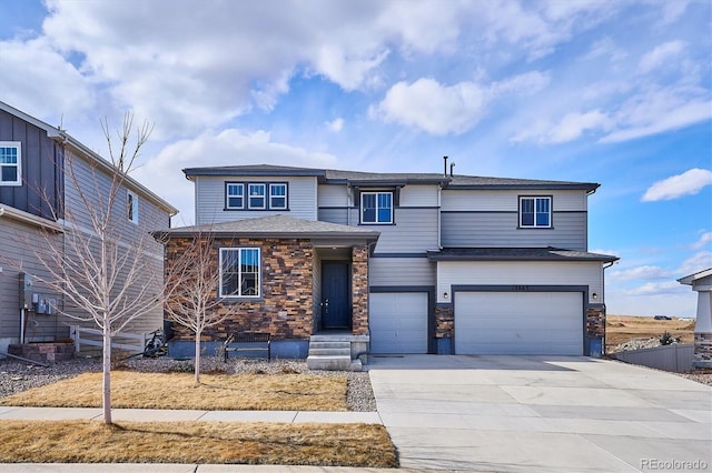 view of front of house featuring a garage, stone siding, driveway, and fence