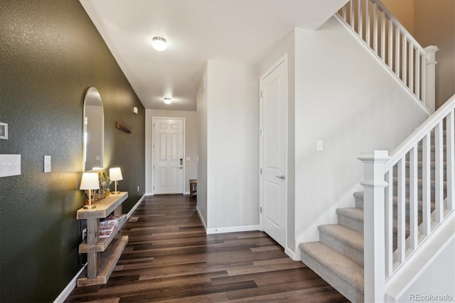 entryway with dark wood-style floors, stairway, and baseboards