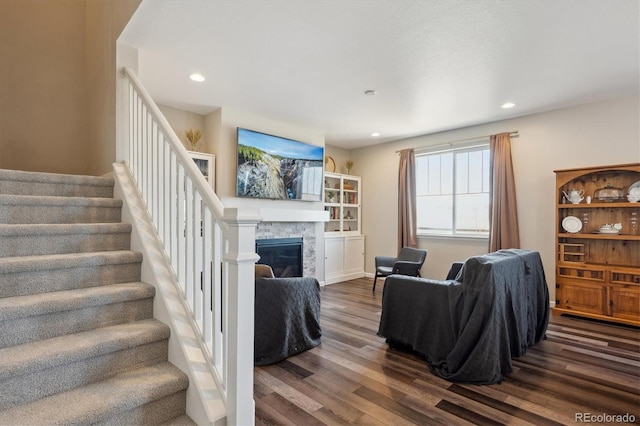 living room featuring stairs, a fireplace, wood finished floors, and recessed lighting