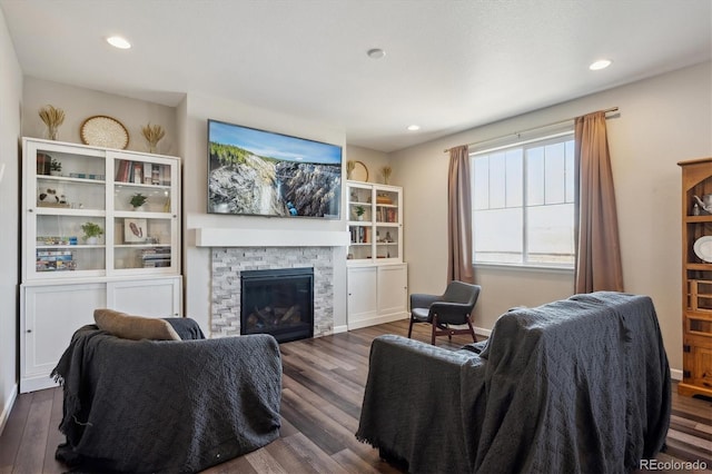 living area featuring dark wood-type flooring, a fireplace, and recessed lighting