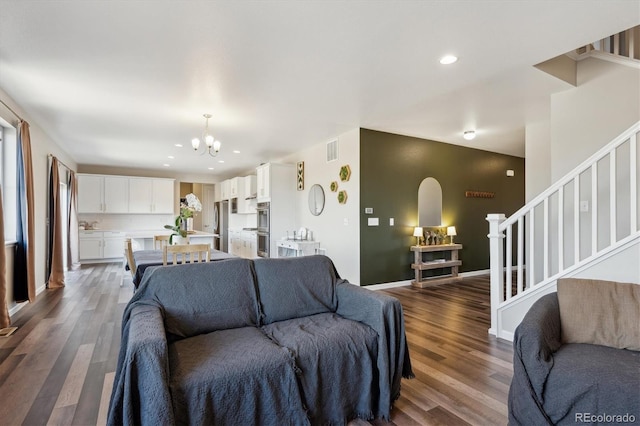 living room featuring baseboards, visible vents, wood finished floors, stairs, and recessed lighting