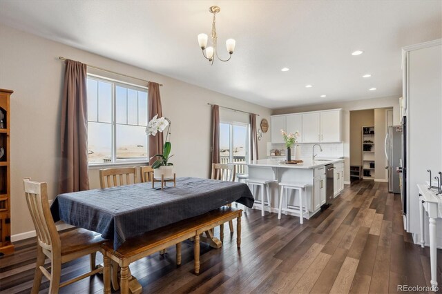 dining area with an inviting chandelier, baseboards, dark wood-type flooring, and recessed lighting