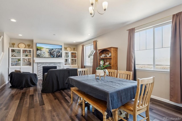 dining space with a chandelier, recessed lighting, a fireplace, baseboards, and dark wood finished floors