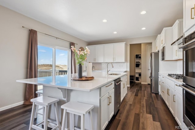 kitchen featuring a center island with sink, light countertops, decorative backsplash, dark wood-type flooring, and white cabinets