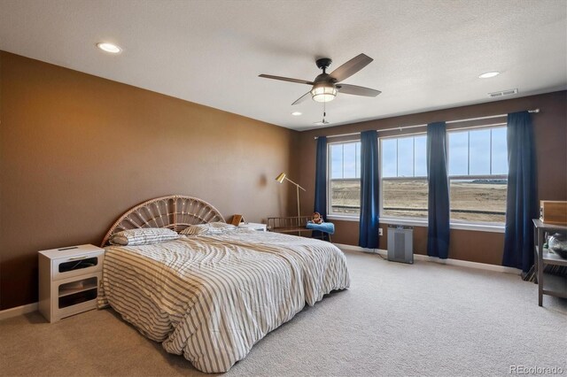 bedroom with a textured ceiling, recessed lighting, carpet floors, visible vents, and baseboards