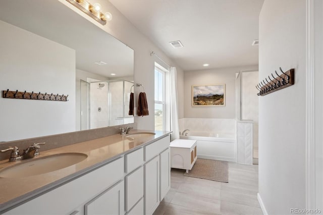 bathroom featuring a garden tub, a sink, visible vents, and a shower stall