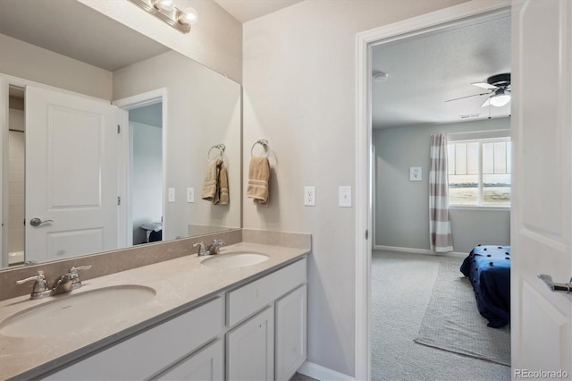 full bathroom featuring ensuite bathroom, double vanity, a sink, and a ceiling fan