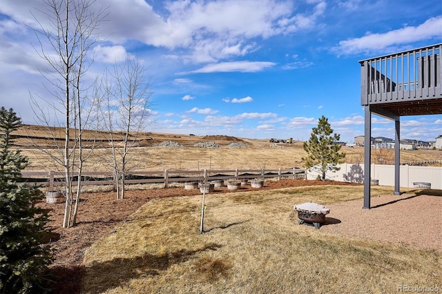 view of yard with an outdoor fire pit, fence, and a wooden deck