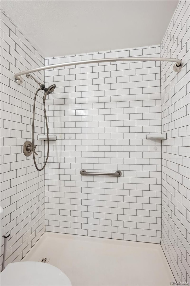 bathroom with a shower stall and toilet