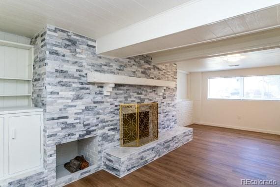 unfurnished living room featuring dark wood-type flooring and a fireplace