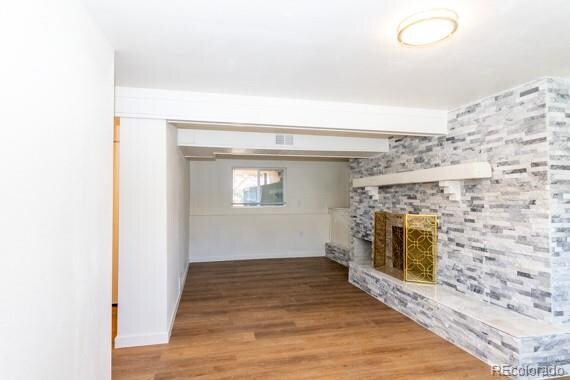 unfurnished living room with a large fireplace and hardwood / wood-style flooring