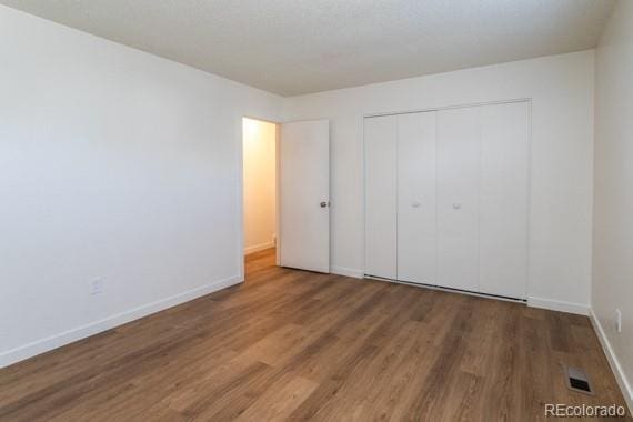 unfurnished bedroom featuring hardwood / wood-style flooring and a closet