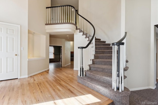 entryway with hardwood / wood-style floors and a high ceiling