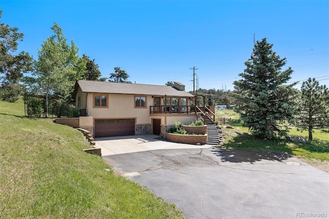 713 Aspen Rd, Golden, CO 80401 - view of front of property with stucco siding, concrete driveway, stairs, a garage, and stone siding