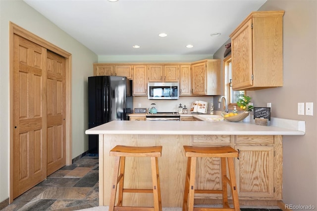 713 Aspen Rd, Golden, CO 80401 - kitchen featuring stainless steel microwave, a peninsula, stove, light countertops, and recessed lighting