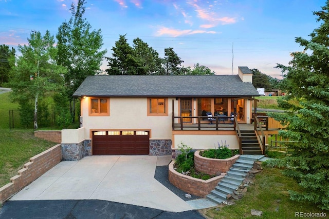 713 Aspen Rd, Golden, CO 80401 - view of front facade featuring stucco siding, stairway, a garage, driveway, and stone siding