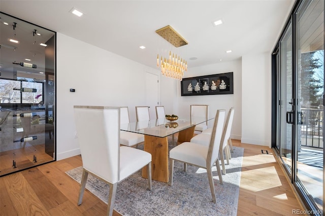 dining space featuring plenty of natural light, floor to ceiling windows, and wood finished floors