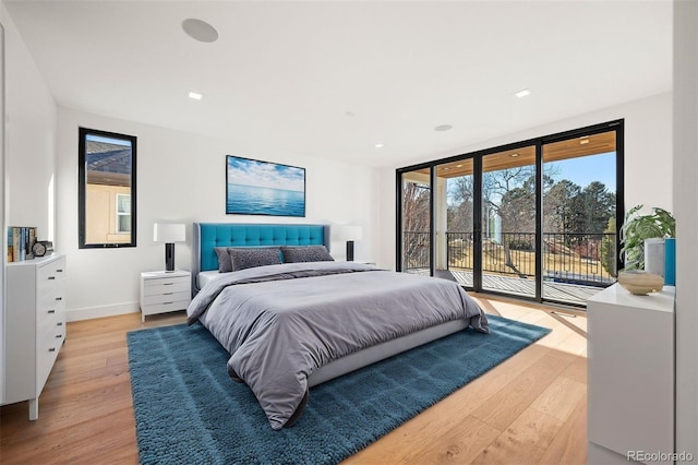 bedroom with access to outside, a wall of windows, light wood-type flooring, and baseboards