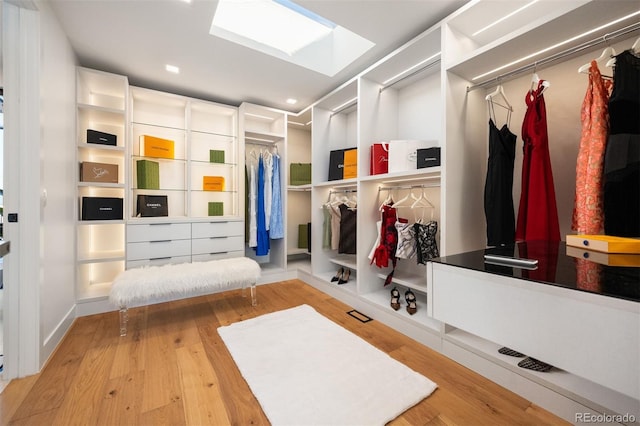 mudroom with a skylight and wood finished floors