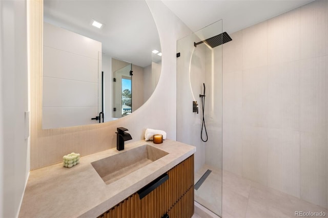 full bath featuring tile patterned floors, walk in shower, and vanity