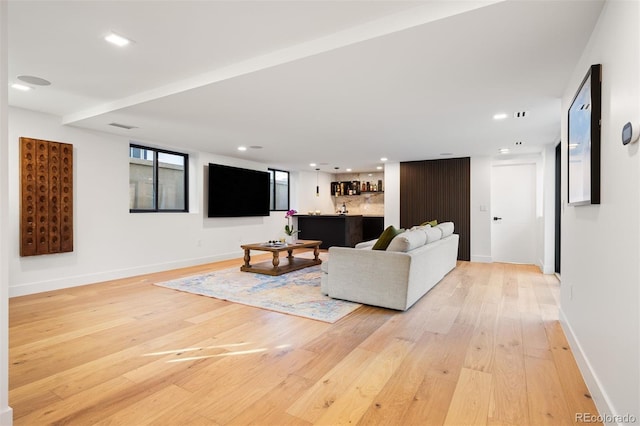 living area with visible vents, bar area, light wood-style flooring, and recessed lighting