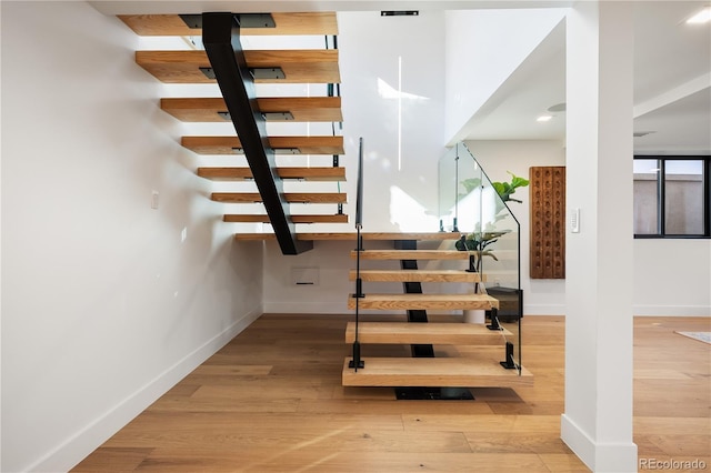 stairs with baseboards and wood finished floors