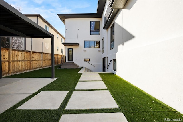 view of yard with entry steps and fence