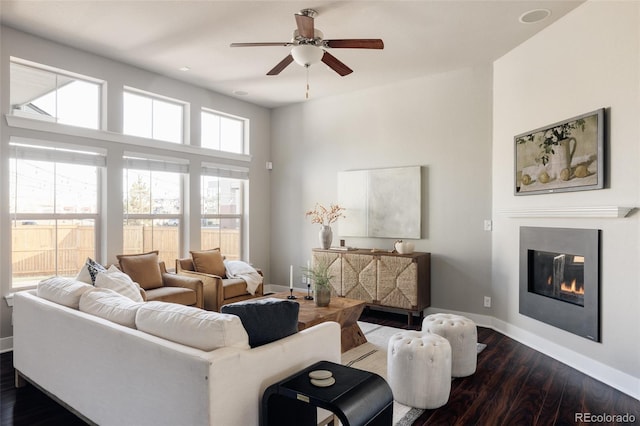 living room featuring ceiling fan and dark hardwood / wood-style flooring