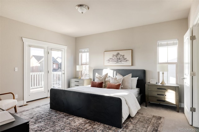 carpeted bedroom featuring multiple windows and access to exterior