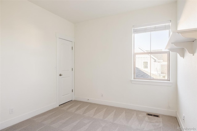 spare room with light carpet and plenty of natural light