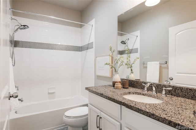 full bathroom featuring tiled shower / bath, vanity, and toilet