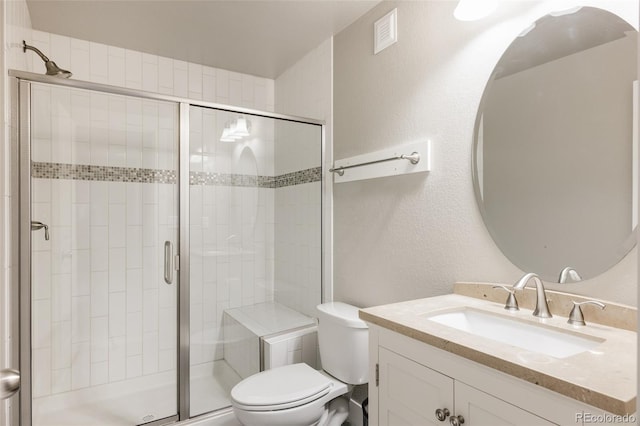 bathroom with toilet, walk in shower, and vanity