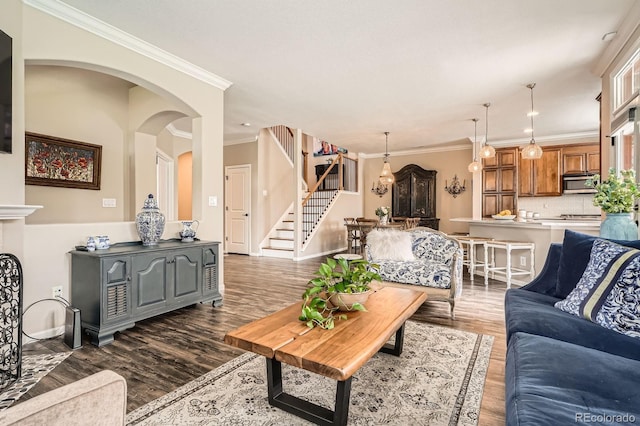 living room with crown molding, dark wood-style flooring, and stairs