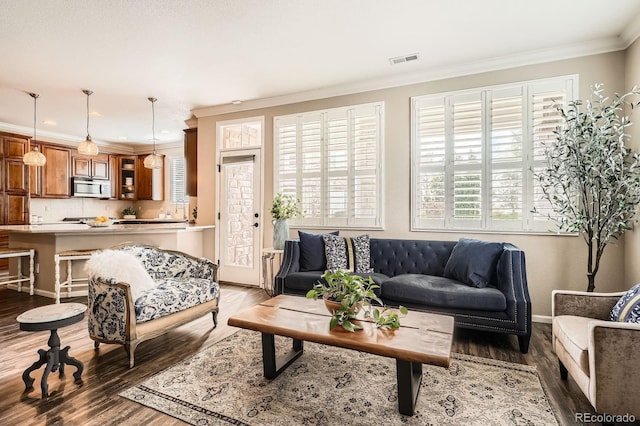 living area with ornamental molding and wood finished floors