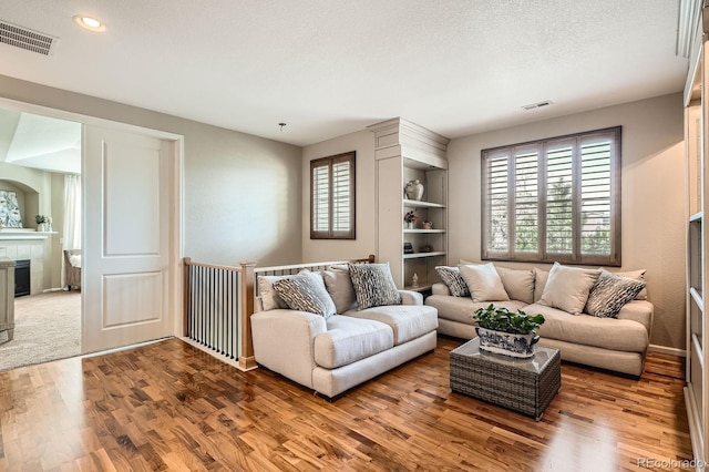 living area featuring a wealth of natural light, wood finished floors, and visible vents