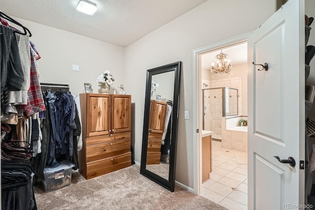 walk in closet featuring a notable chandelier and light tile patterned floors