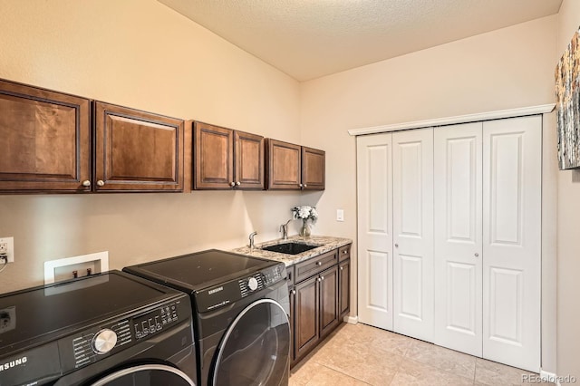 clothes washing area with a sink, separate washer and dryer, light tile patterned floors, and cabinet space