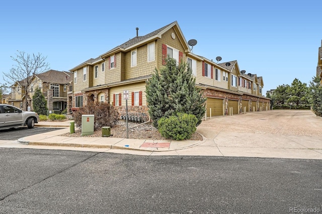 view of front of property featuring a residential view, an attached garage, and driveway