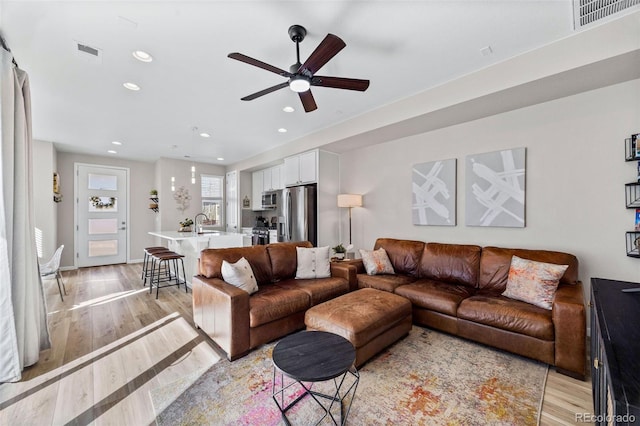 living room featuring recessed lighting, visible vents, ceiling fan, and light wood finished floors