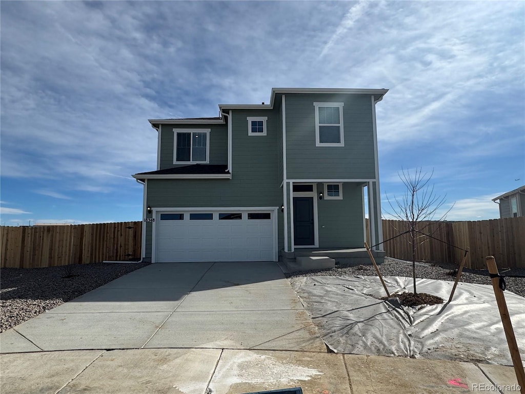 view of front of house featuring a garage, fence, and driveway