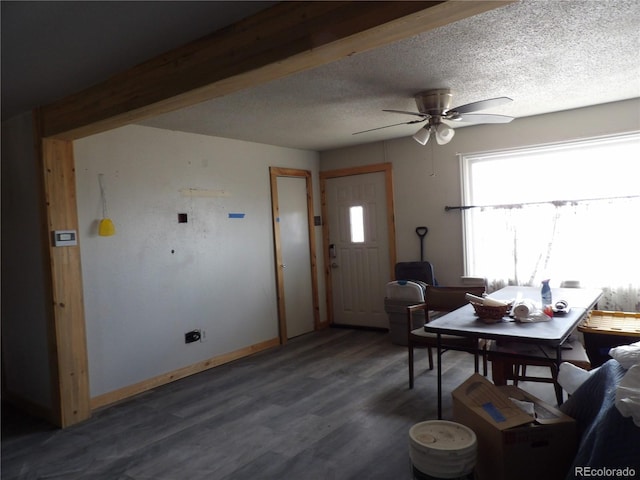 living area featuring baseboards, a textured ceiling, ceiling fan, and wood finished floors