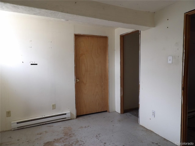 unfurnished room featuring concrete flooring and a baseboard radiator