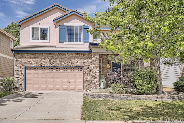 1179 S Fultondale Cir, Aurora, CO 80018 - view of front facade with an attached garage, stucco siding, concrete driveway, and stone siding